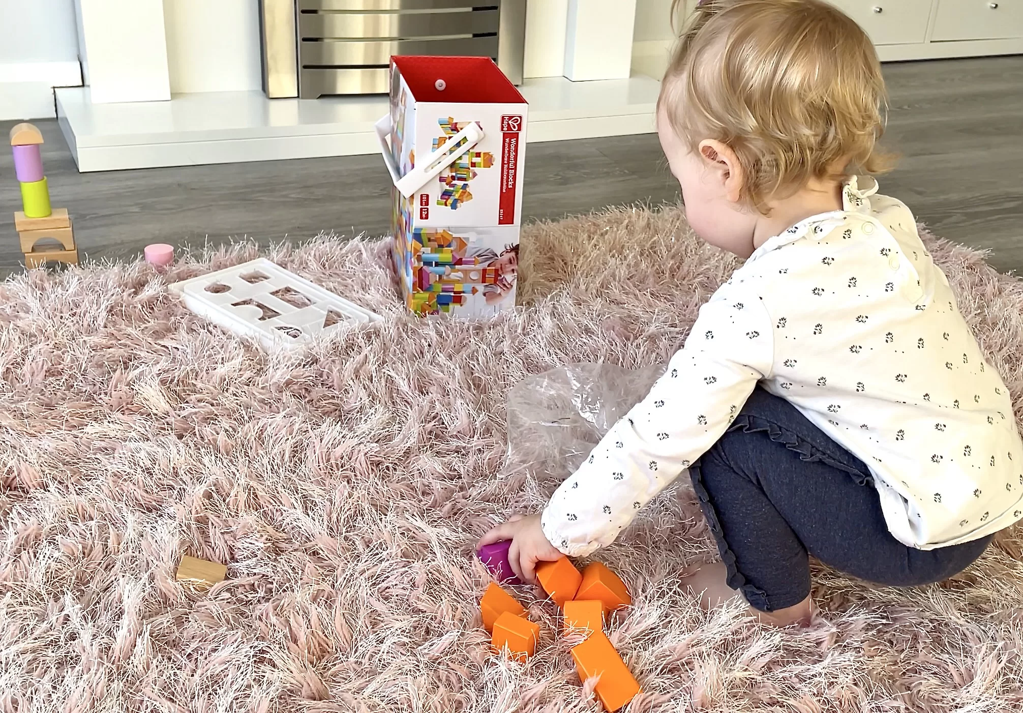 toddler playing with wooden building blocks